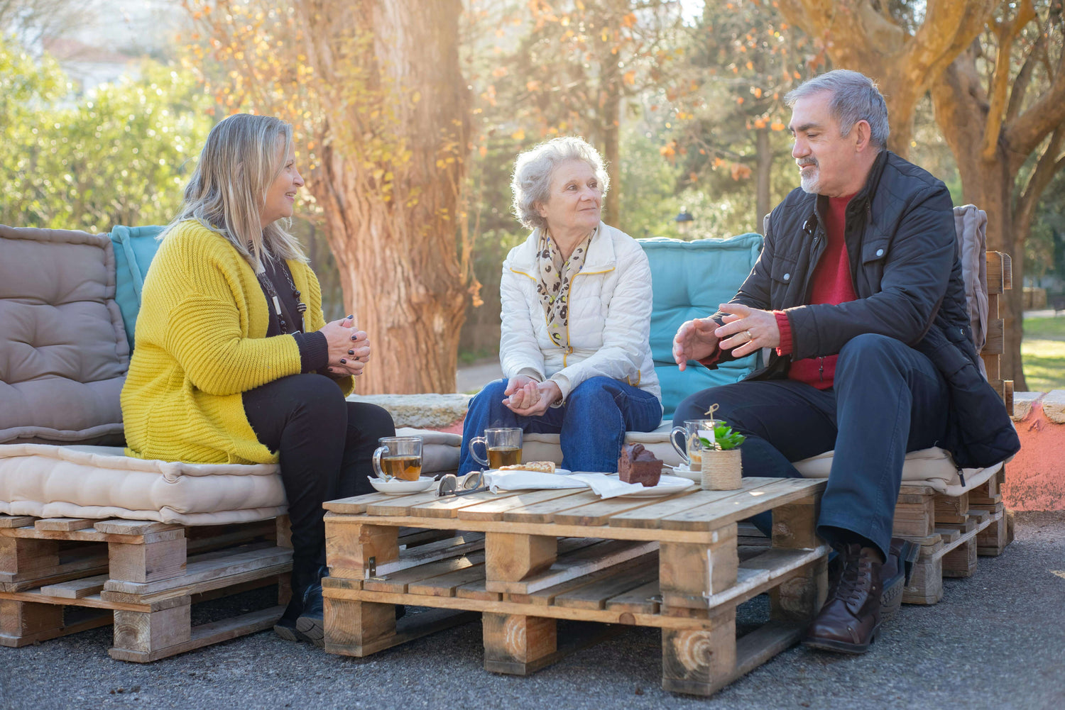 Older adults talking outdoors with affordable OTC hearing aids improving hearing clarity.